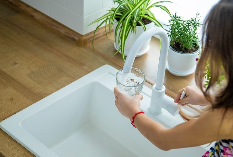 Un verre d’eau rempli au robinet de cuisine